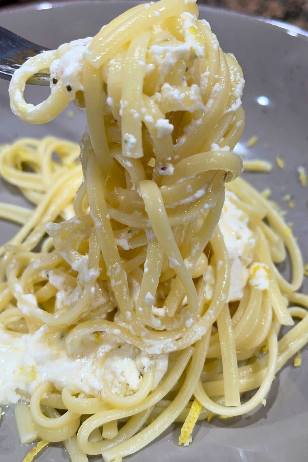 A fork loaded with freshly prepared lemon cottage cheese alfredo sauce 